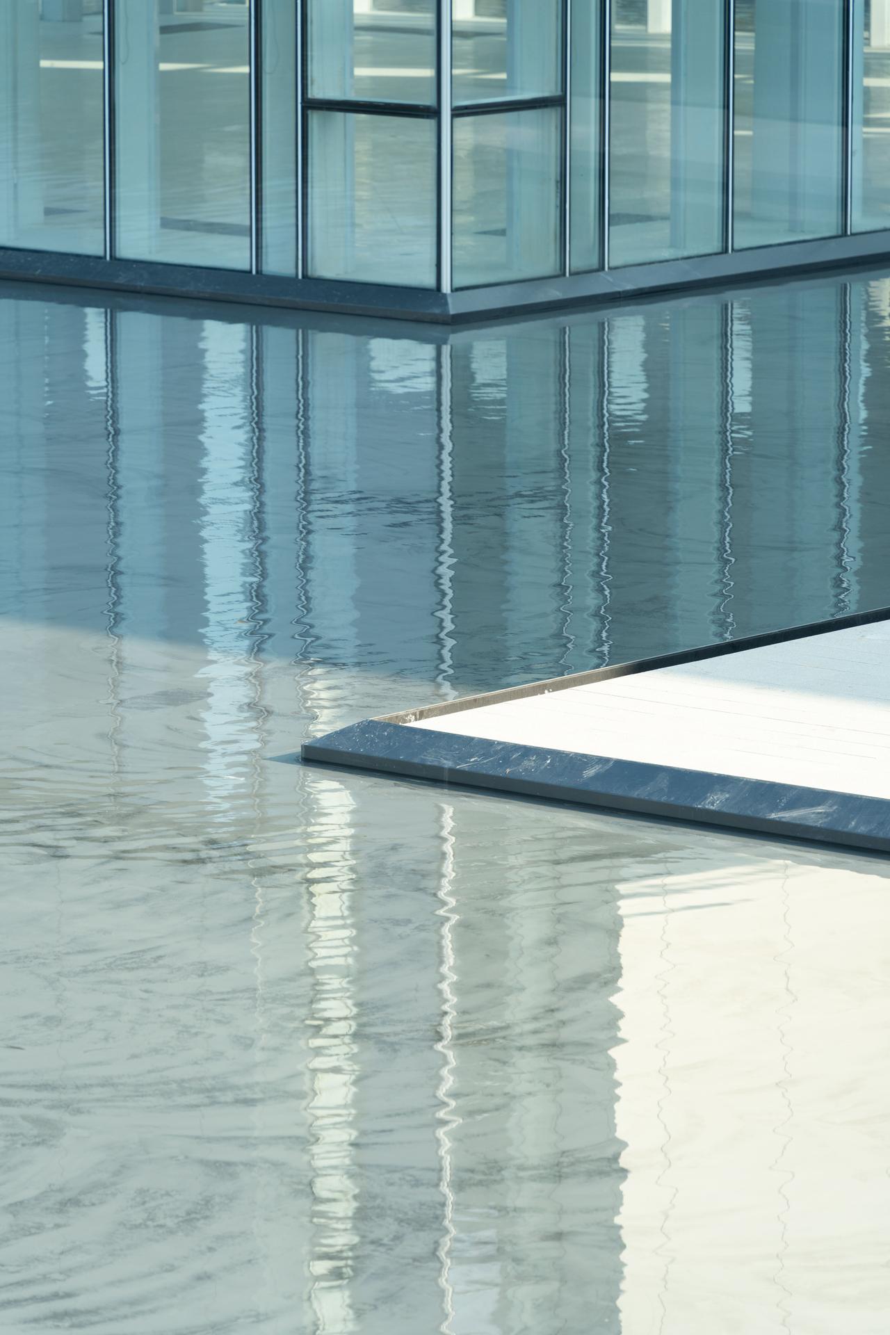 Glossy polished epoxy floor reflecting a modern glass building interior
